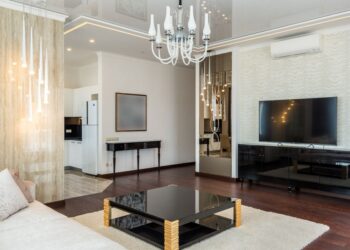 Een modern zwart tv meubel in een stijlvolle woonkamer met minimalistisch design en warme verlichting.