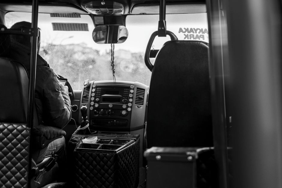 Een buschauffeur achter het stuur van een moderne bus, klaar om passagiers te vervoeren.
