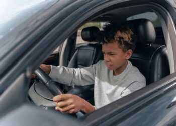 Een rijinstructeur geeft les aan een leerling in een auto, symboliserend de kosten en prijsopbouw van rijlessen.