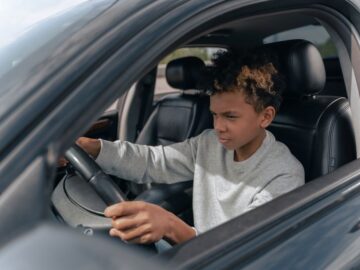 Een rijinstructeur geeft les aan een leerling in een auto, symboliserend de kosten en prijsopbouw van rijlessen.