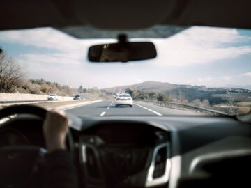Een auto met een dashcam en achtercamera op de weg, die beveiliging en extra zicht biedt tijdens het rijden.