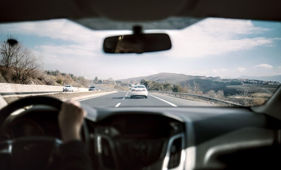 Een auto met een dashcam en achtercamera op de weg, die beveiliging en extra zicht biedt tijdens het rijden.