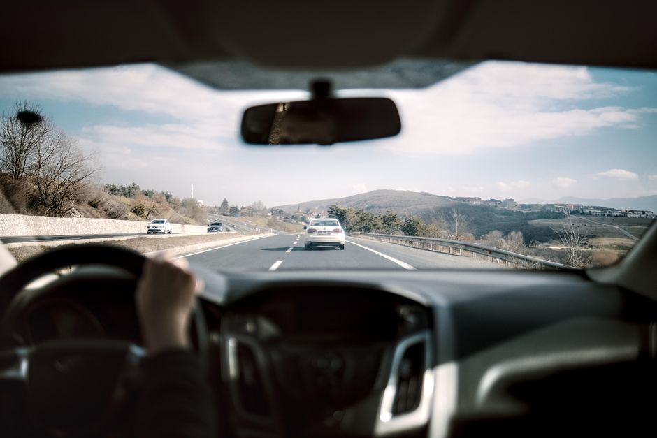 Een auto met een dashcam en achtercamera op de weg, die beveiliging en extra zicht biedt tijdens het rijden.